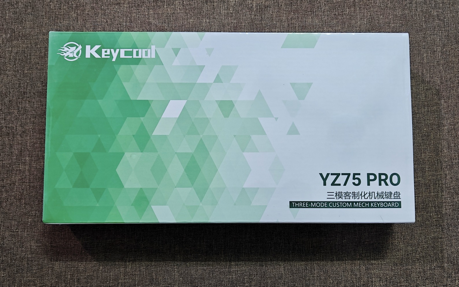Bàn Phím Cơ Keycool YZ75 (New Fullbox) - 3 Mode, Hotswap Mạch Xuôi, LED Viền | MKShop 8 Hộp đựng bàn phím Keycool YZ75 Pro màu trắng họa tiết tam giác xanh lá đặt trên nền vải nâu